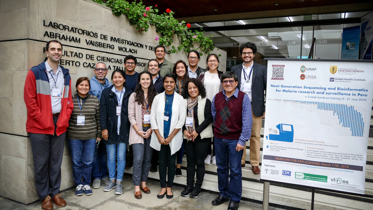 Peru training Trainers and attendees stand together outside a building with the words Laboratorio de Investigació n de Productos Naturales de la Amazonia