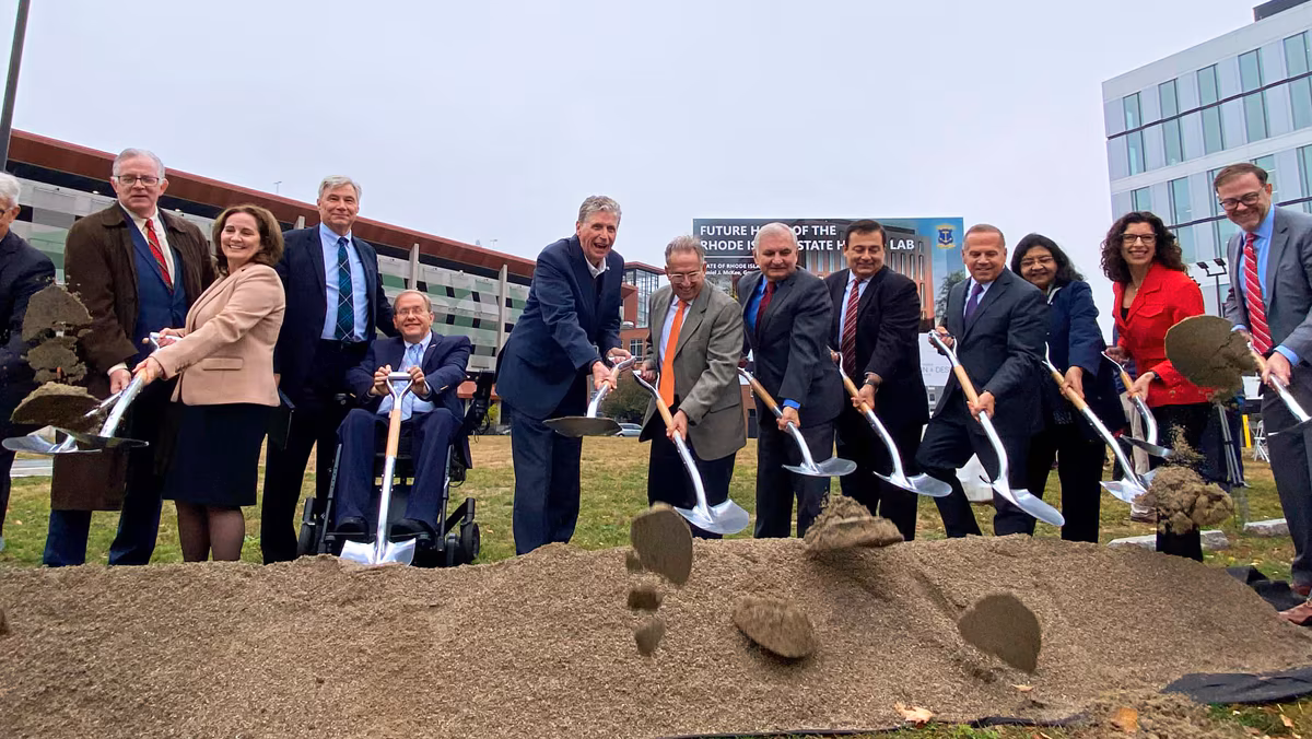 Rhode Island groundbreaking Thirteen people with shovels scooping and throwing out dirt toward the camera