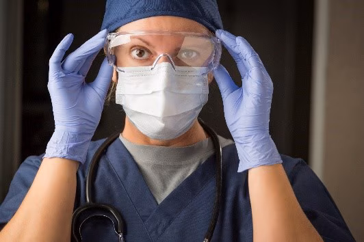 Healthcare worker in mask, gloves, and protective eyewear