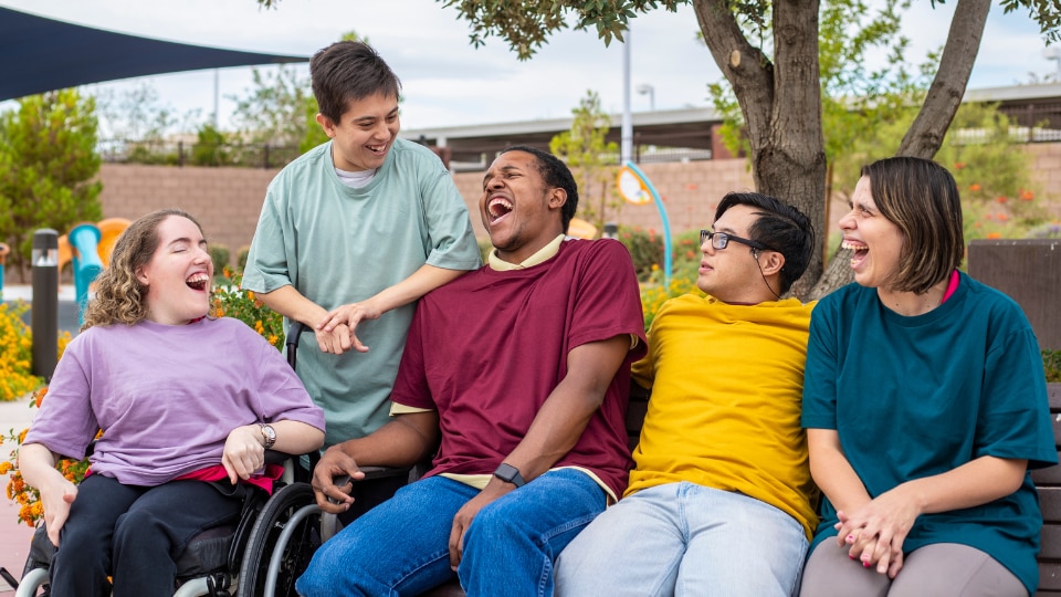 — title missing — Group of young adults with various physical disabilities laughing together.