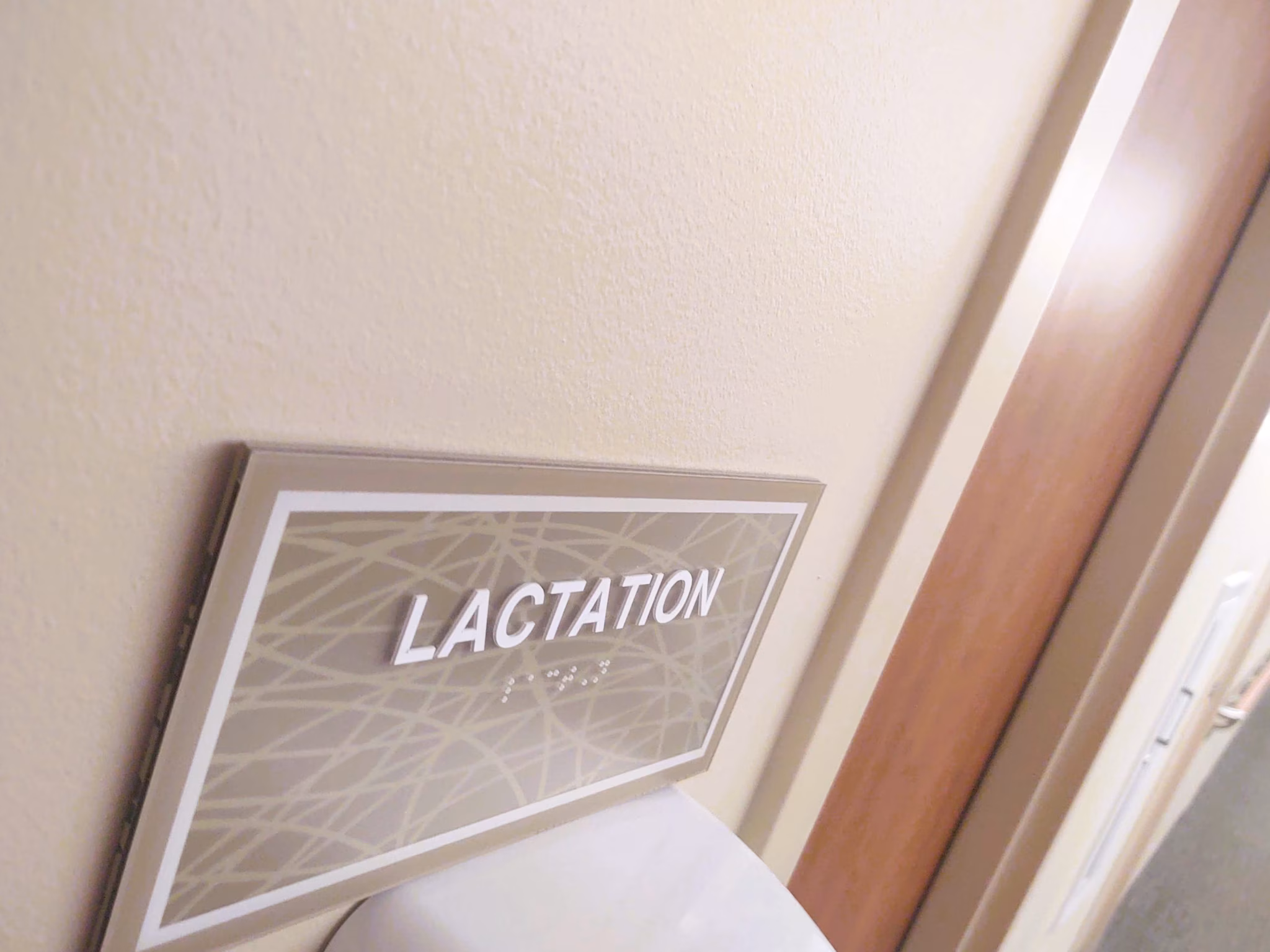 Lactation room Sign on a wall outside of a door that reads "Lactation"