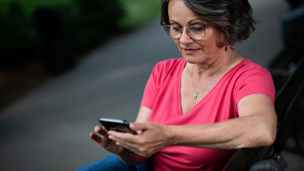 patient reminder A woman reading a text message on her cell phone