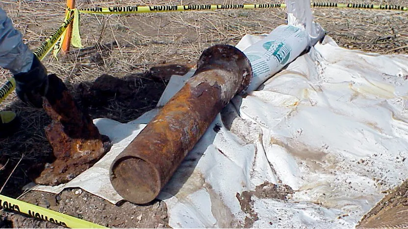 Recovered chemical agent mortar laying on a tarp on the ground.