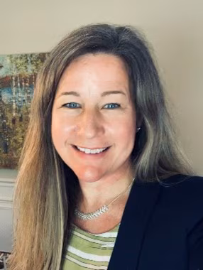 Courtney H. Lias, Ph.D. A headshot of Dr. Lias. She has long blonde hair and is wearing a black suit jacket with a green and white striped shirt.