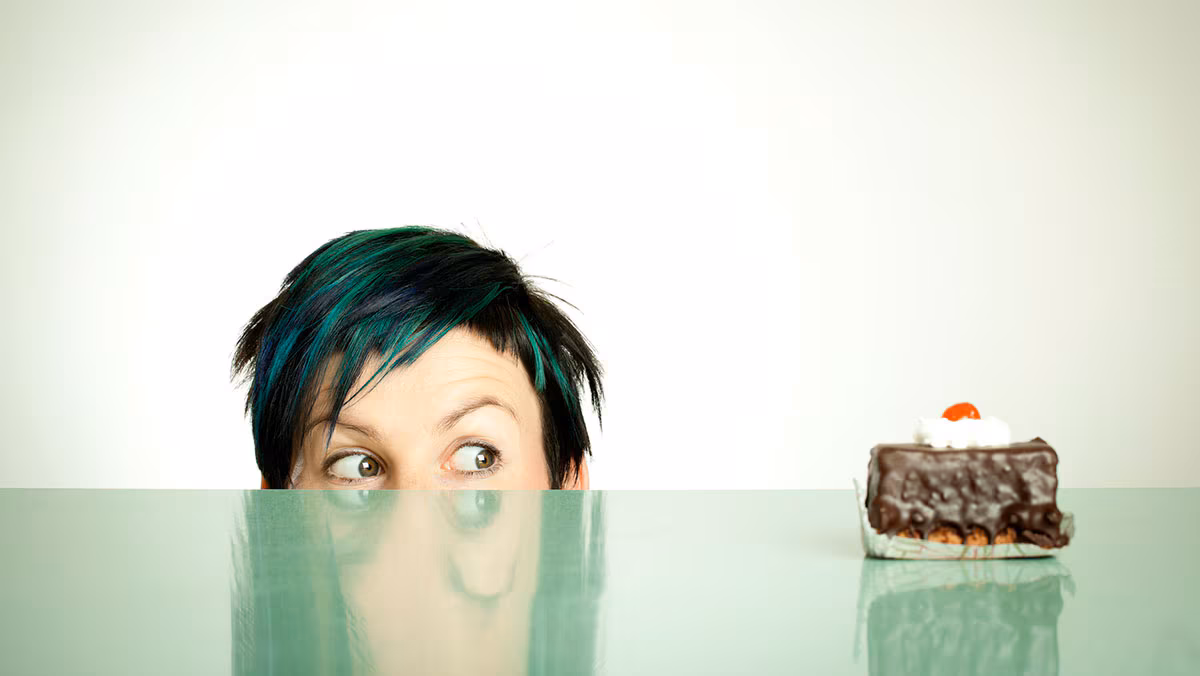 woman eyeing piece of cake