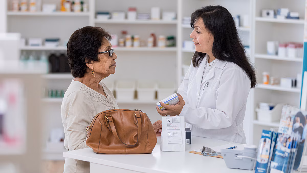 woman pharmacist talking to an older woman