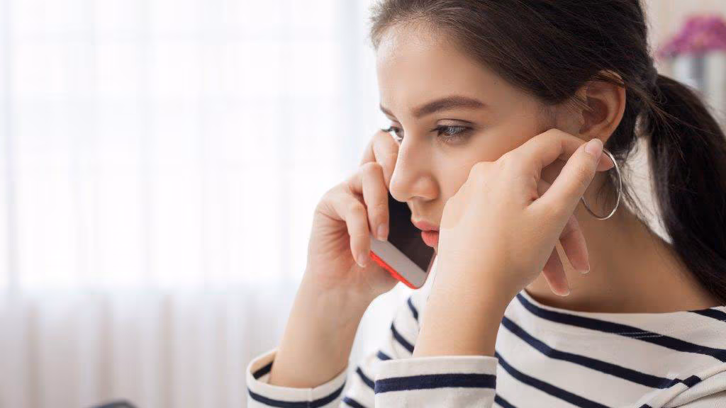 Unhappy woman talking on phone.