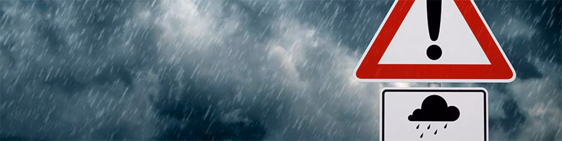 Una señal de precaución con una mala tormenta en el fondo