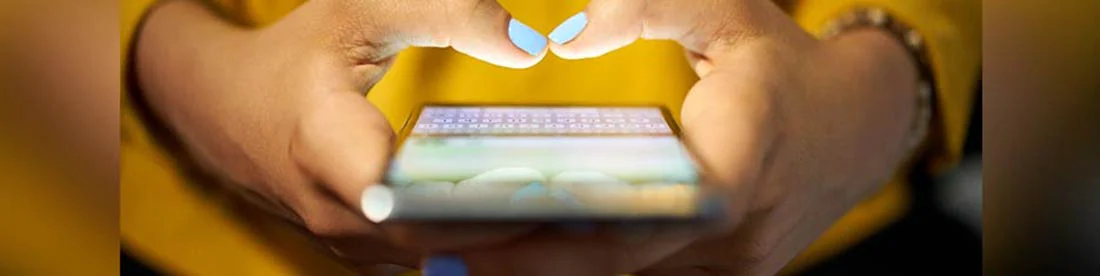 Una foto de una mujer enviando mensajes de texto en su teléfono.