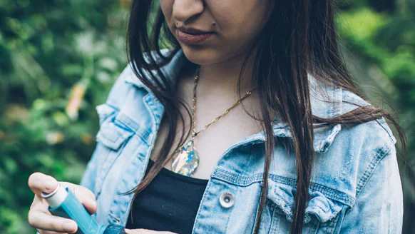 People with asthma are at higher risk of developing serious flu complications, even if their asthma is mild or their symptoms are well-controlled by medication. A girl holding a nebulizer for asthma.