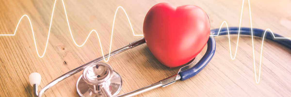 heart-disease-banner Stethoscope with a red heart and a heartbeat line on a wooden surface, symbolizing heart health.