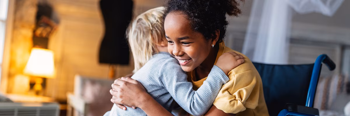 Happy multiethnic family. Smiling little girl with disability in wheelchair at home Happy multiethnic family. Smiling little girl with disability in wheelchair at home