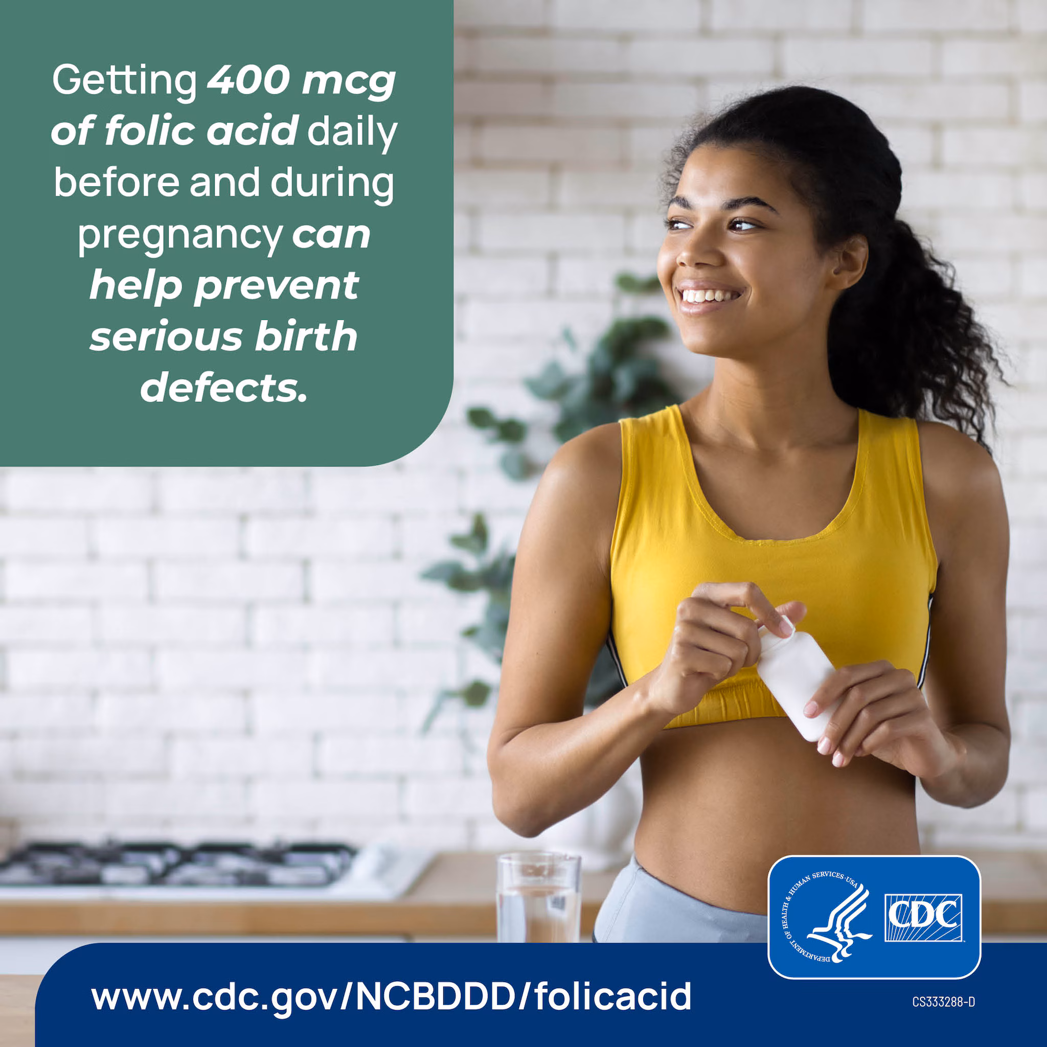 A person standing in their kitchen holding a supplement bottle.