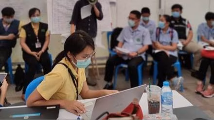 Dr. Ern and Department of Disease Control Thailand staff and healthcare personnel during a COVID-19 outbreak daily briefing