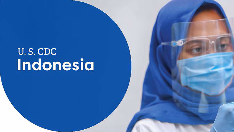 Healthcare worker in protective gear and headscarf, labeled "U.S. CDC Indonesia."