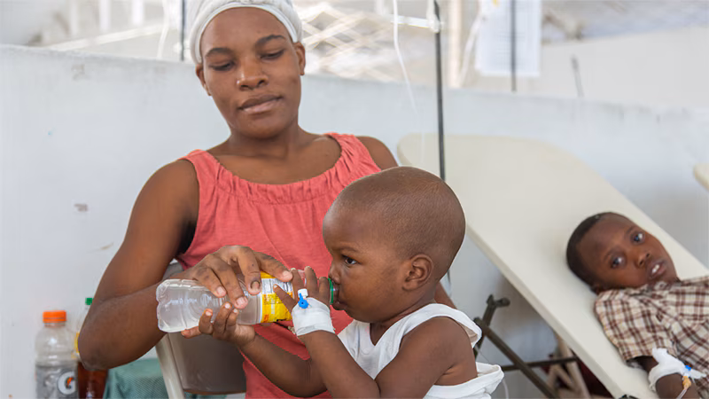 A young child receives oral rehydration therapy, a critical therapy, at a cholera treatment center in Haiti.