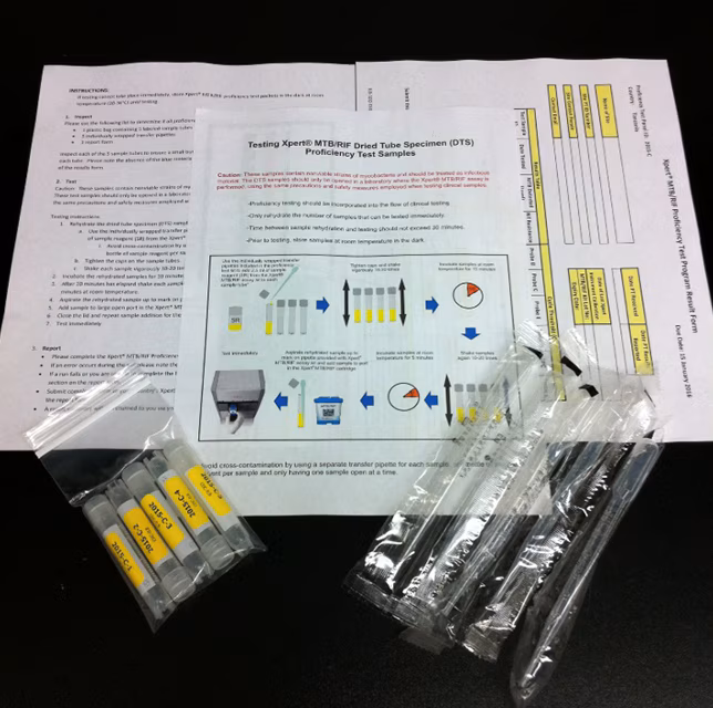 A pamphlet, vials, and materials that are included in an Xpert TB Proficiency Testing program sample kit.