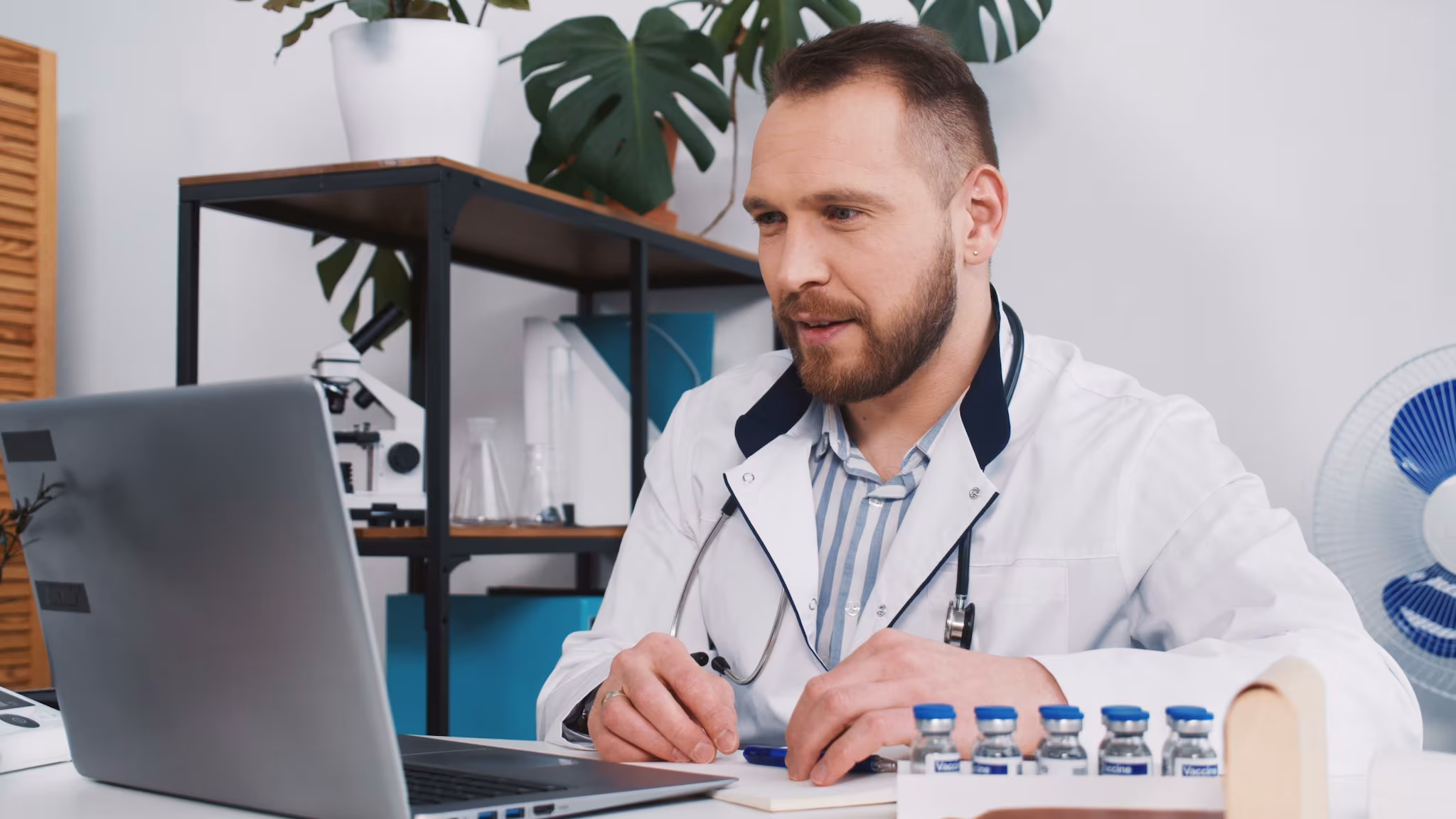 Medical professional using laptop computer Health care professional sitting at a desk with a laptop computer.