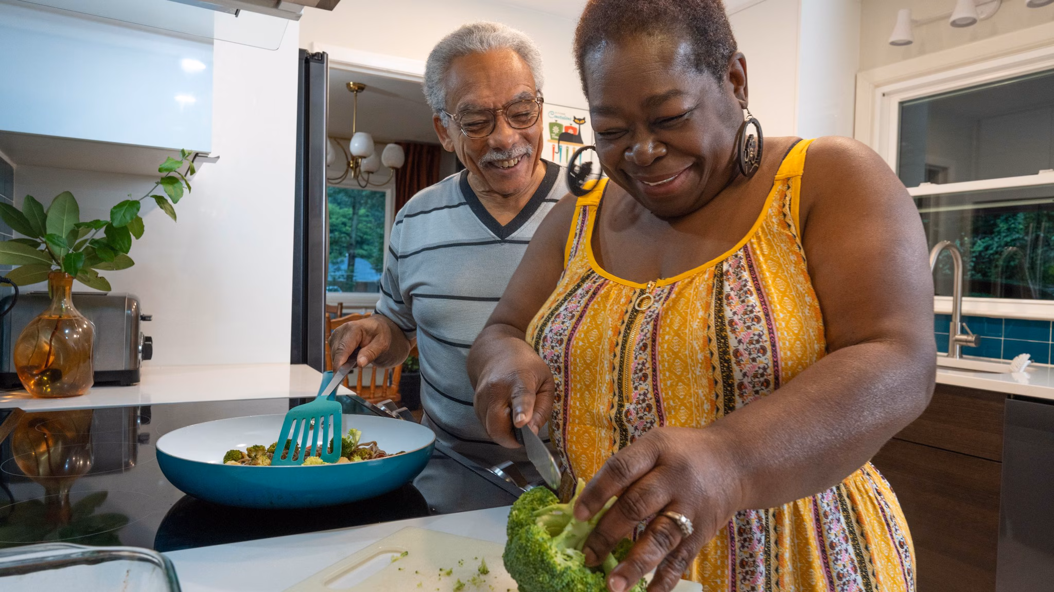 — title missing — Couple making a meal on the stovetop in a home kitchen.