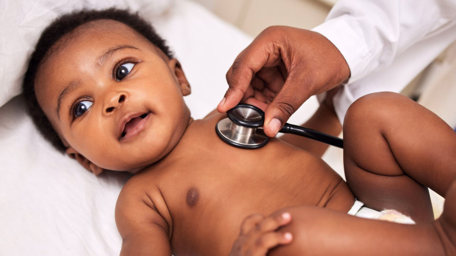 Caregiver listening to a baby's heart A baby having his heart listened to with a stethoscope
