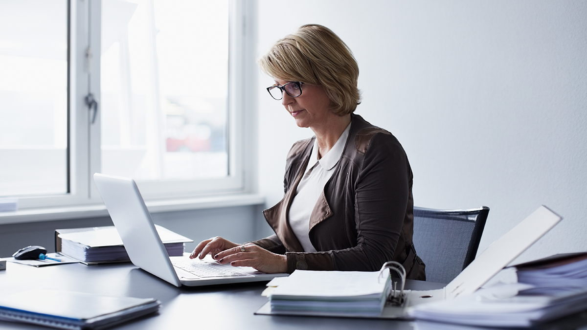 What is Influential Scientific Information Business professional sitting at their desk reviewing scientific information on their laptop