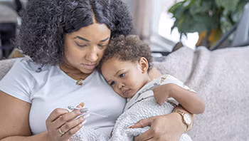 A mother snuggles with her sick child.