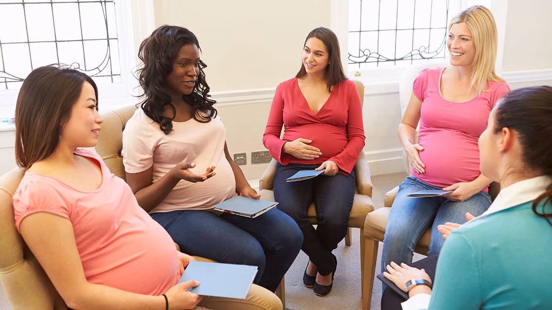 Group of pregnant women A group of pregnant in a meeting having a discussion.