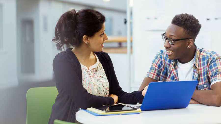 A counselor speaking with a teenage student.