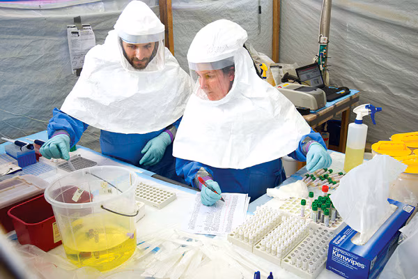 Photo of people wearing protective attire while testing Ebola samples