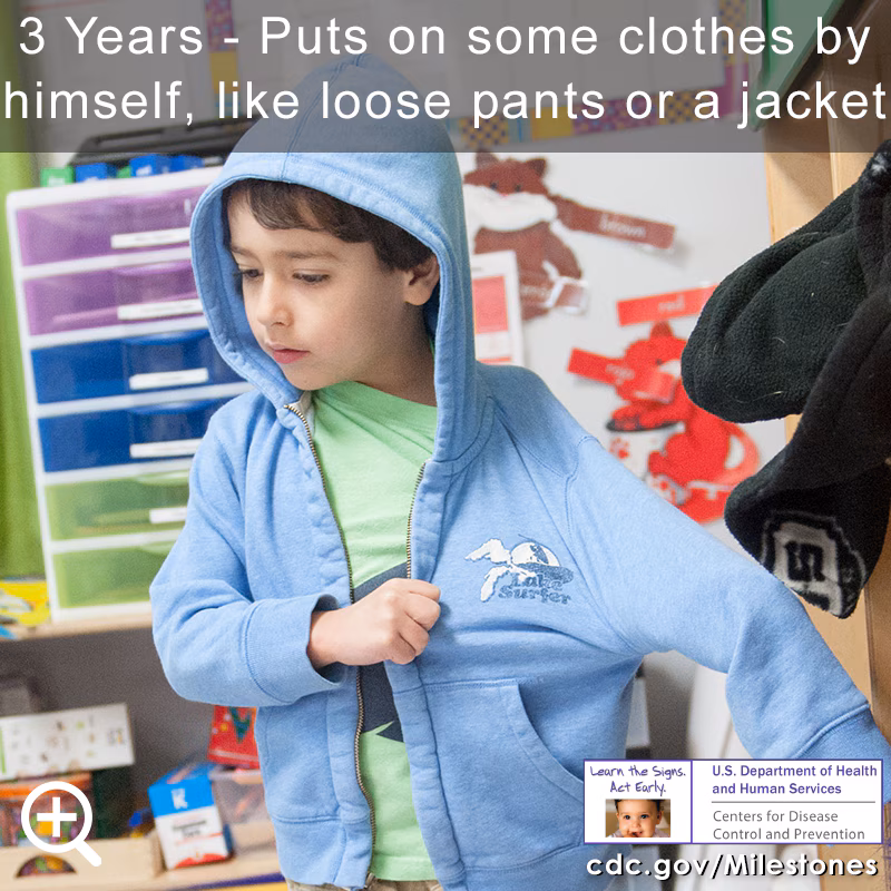 Puts on some clothes by himself, like loose pants or a jacket