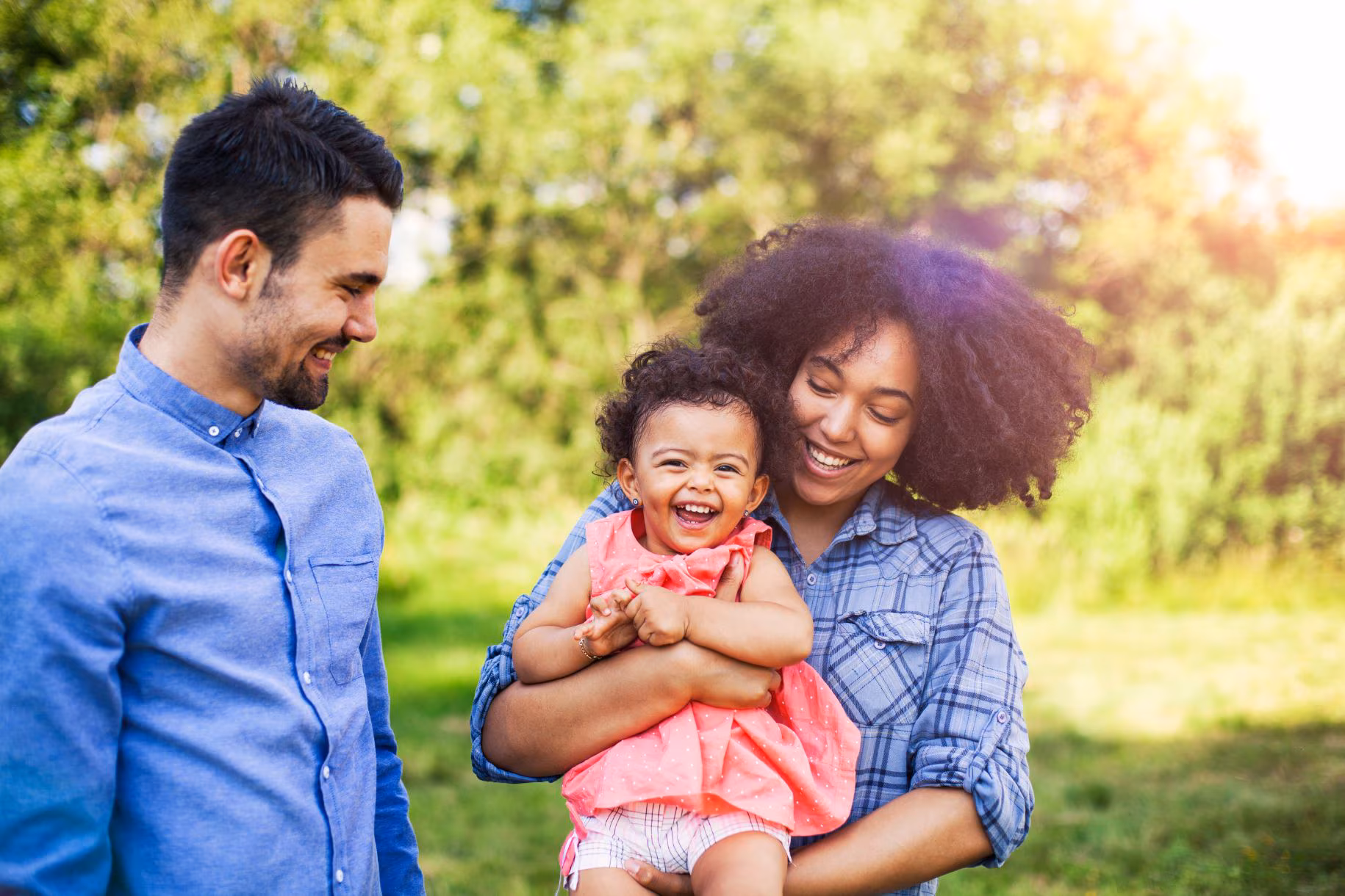 Family walking in field carrying young baby girl Family walking in field carrying young baby girl