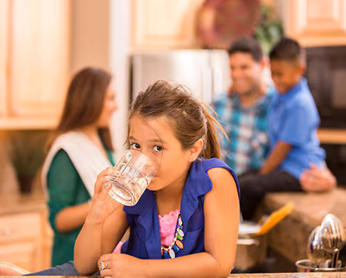 una niña bebiendo agua