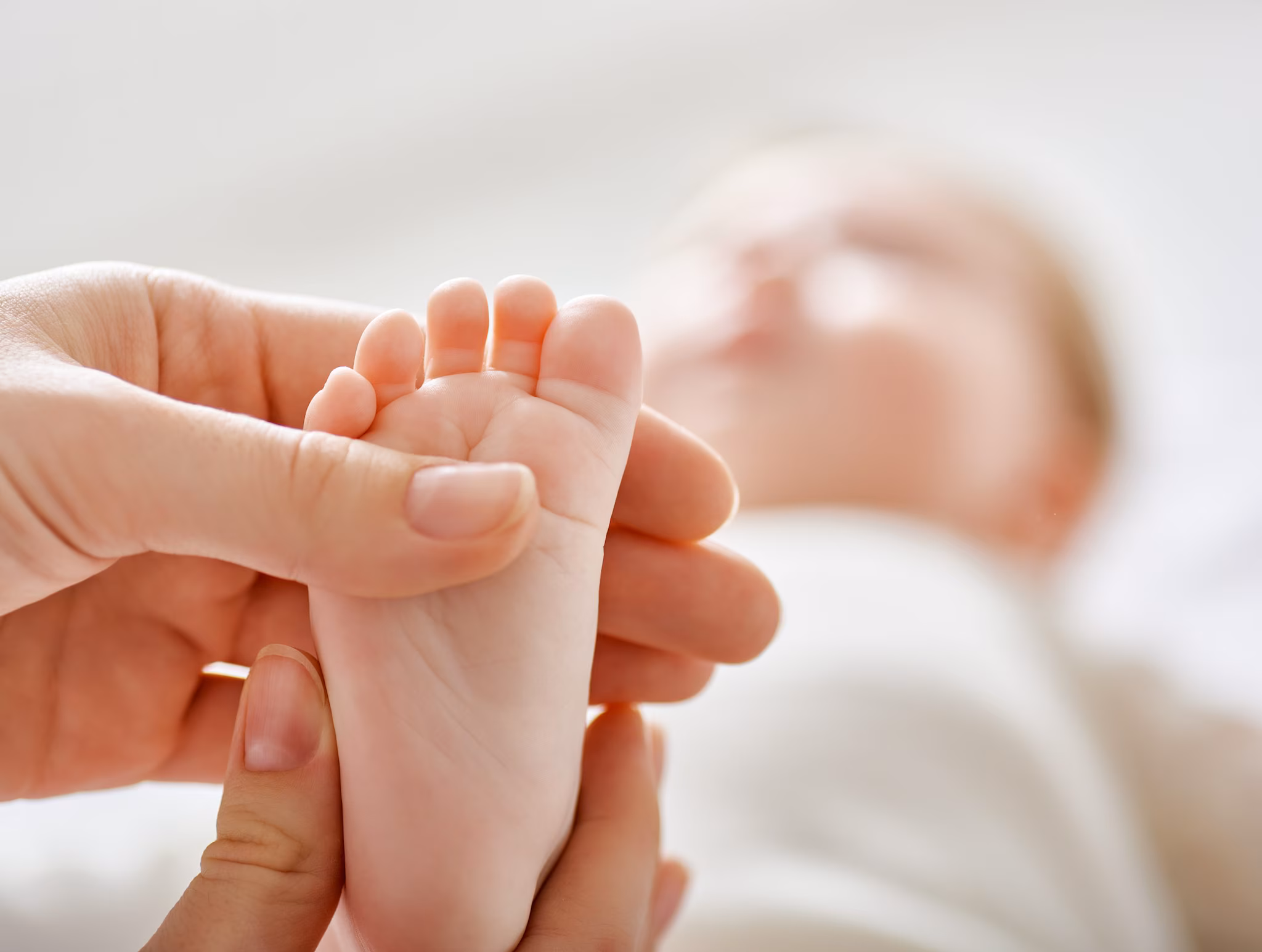 Image of a newborn's feet being held by mother.