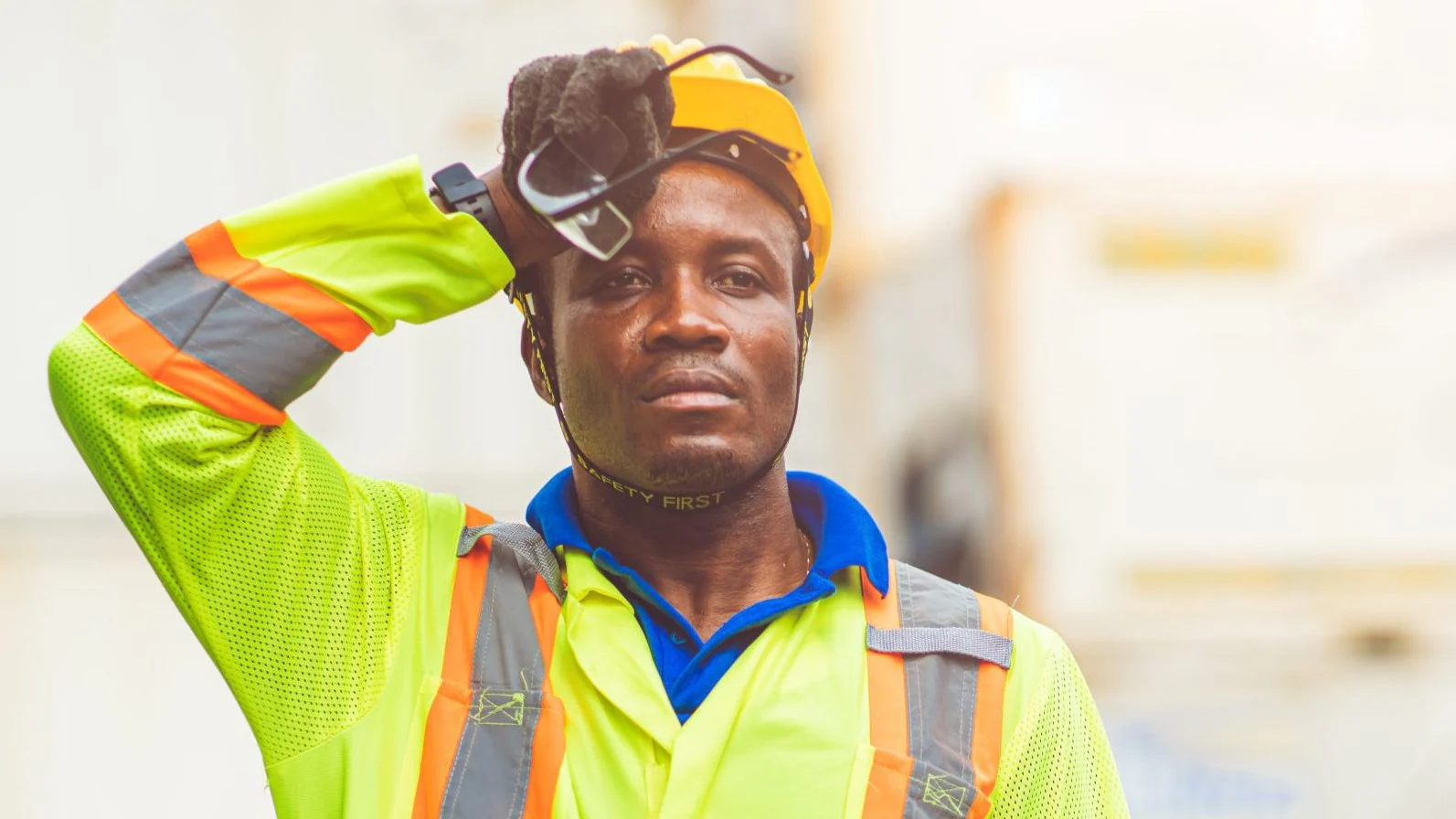 Outdoor worker A construction worker wipes his brow while working outside on a hot day.