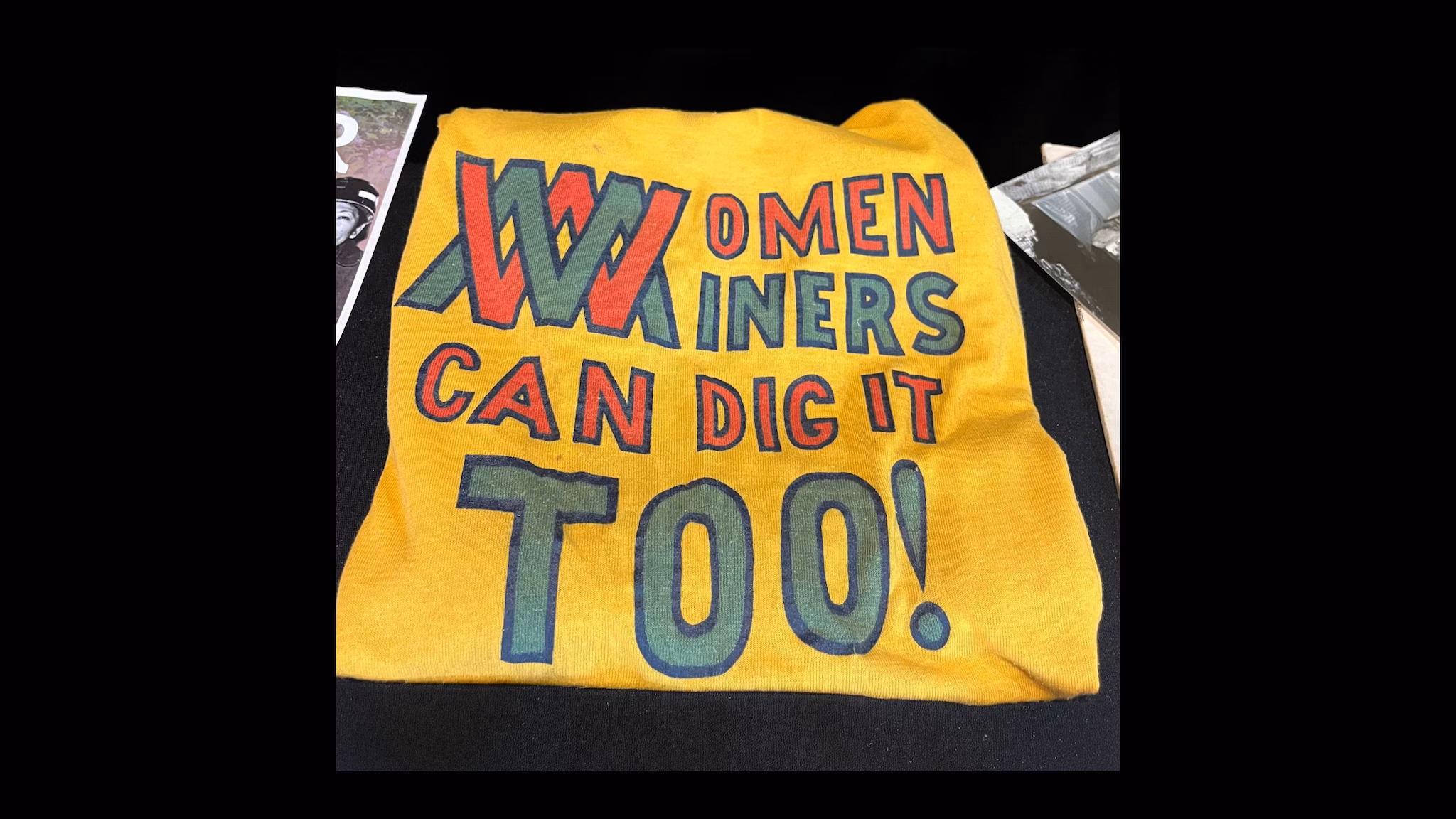 December DD image "Women Miners Can Dig It Too!” printed in bright colors on a yellow t-shirt