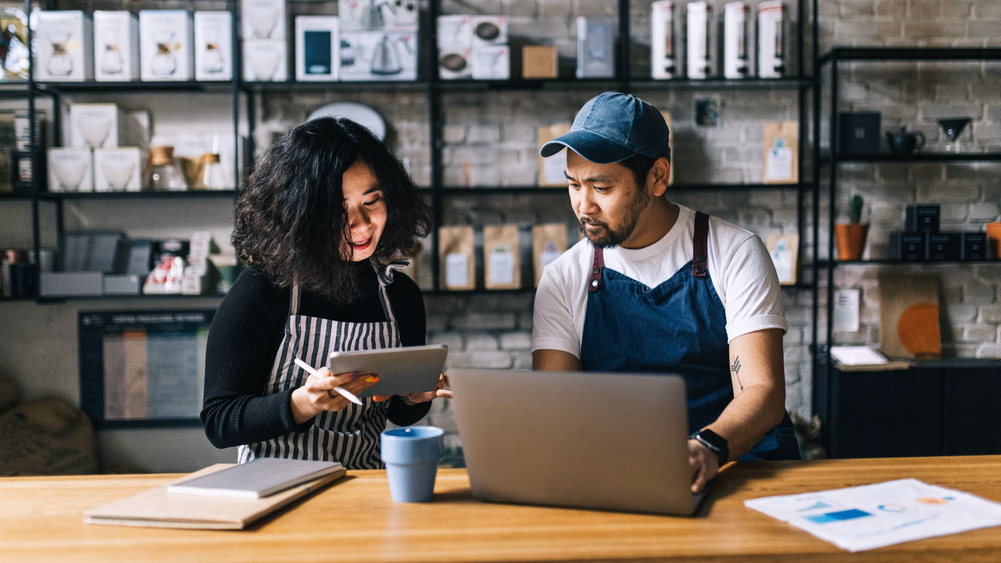 — title missing — two people sitting in front of a table with a laptop and notebook