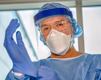 Healthcare worker wearing full PPT ensemble Healthcare worker wearing full PPT ensemble