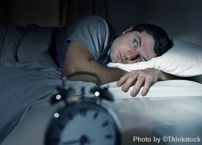 Man waking up to alarm clcok in the morning