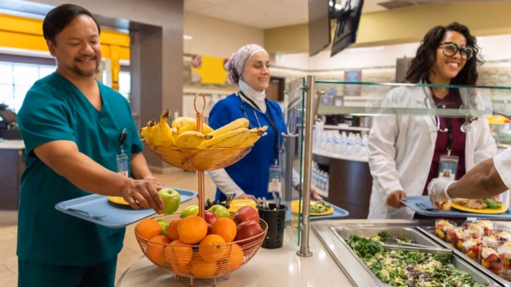 — title missing — Medical staff choosing healthy options in serving line of hospital cafeteria.