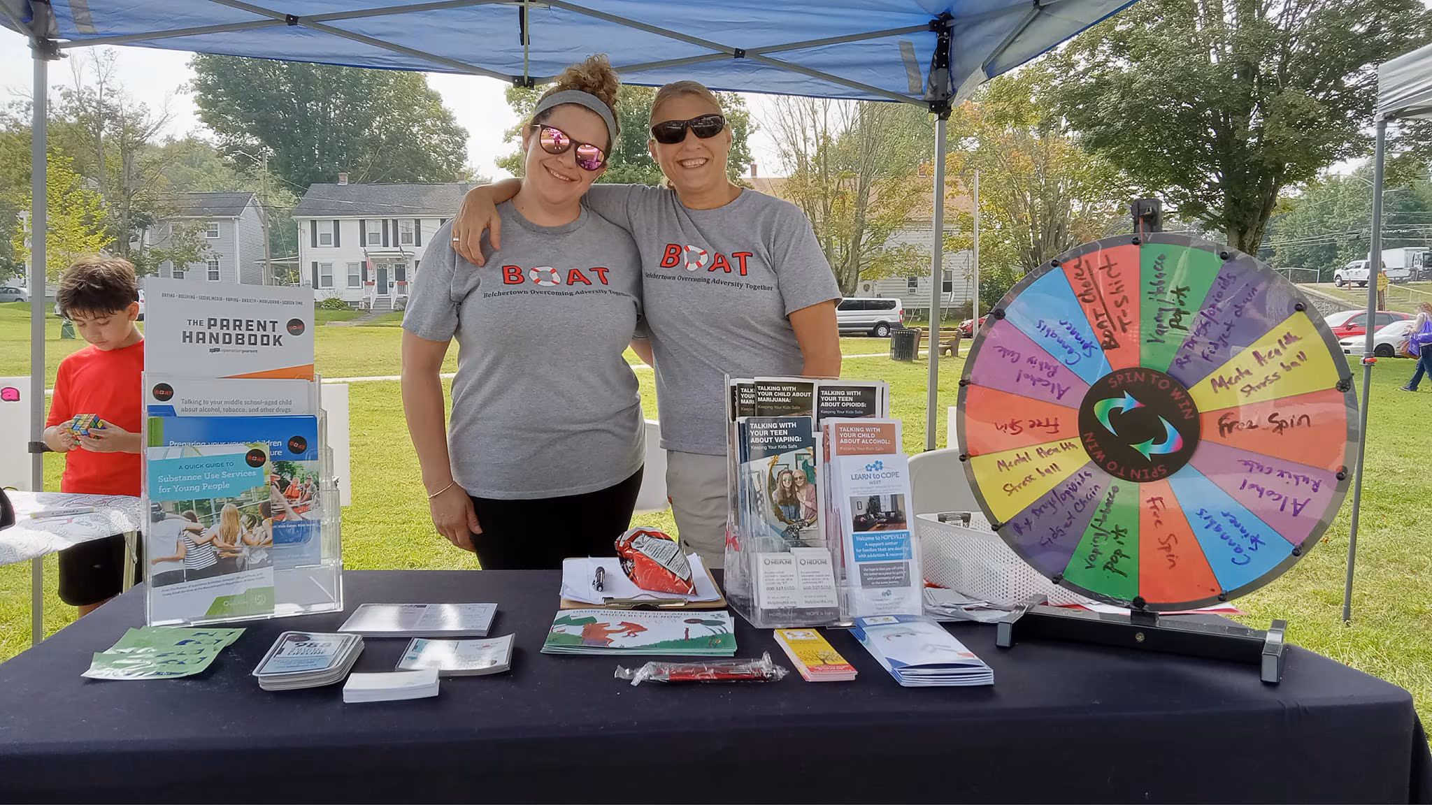 DFC-BelchertownStory-Thumbnail Two adults staffing the BOAT coalition table at community event