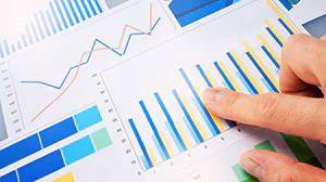 Finger pointing to a generic graph page with several colorful graphs present.