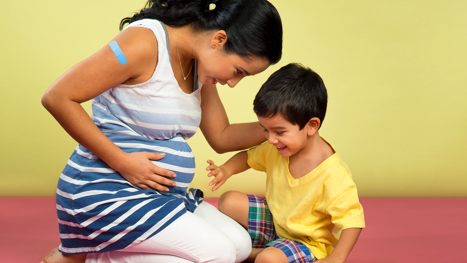 mom and child Pregnant mother sitting with her son.