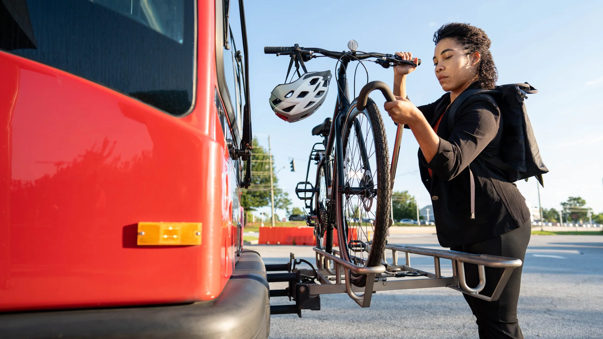 — title missing — Woman loading bicycle onto bus.