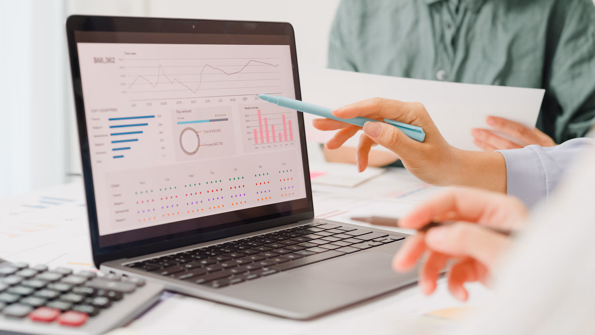 Photograph of people gathered around a laptop analyzing data.