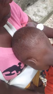 Young boy rests his head on a woman's chest
