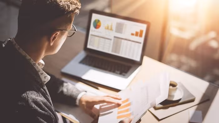 A teacher looking at data analysis on a laptop.