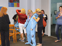 A group of people in a classroom setting interacting with each other.