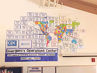 A CDC Emergency Operations Center educational resources hangs on a white board.
