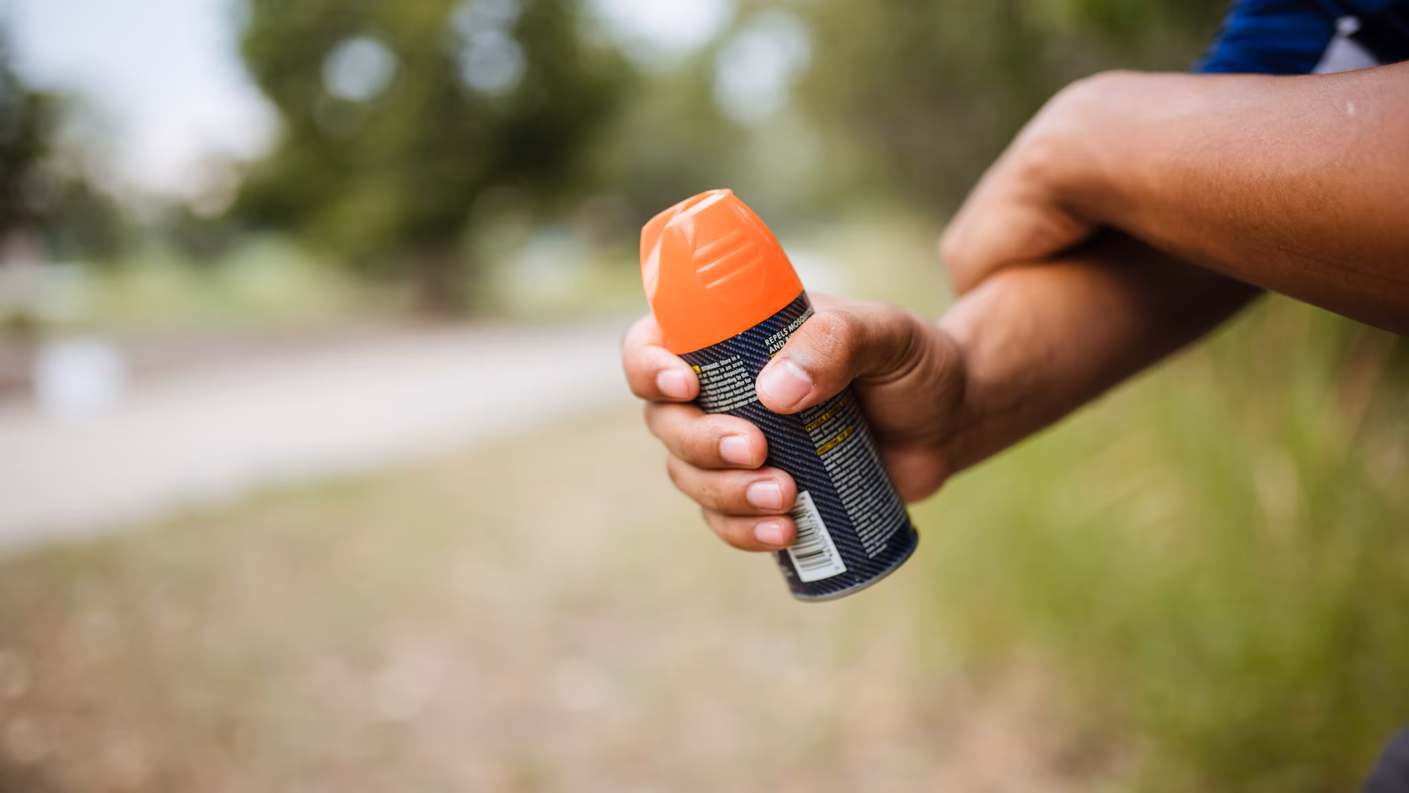 Person rubbing in insect repellent on their arm