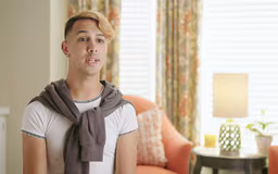 video15 Hispanic male in room with window and chair behind him talking to camera